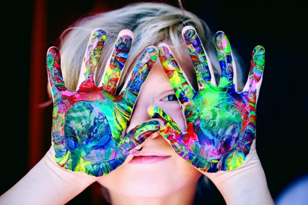 niño con las manos pintadas de colores