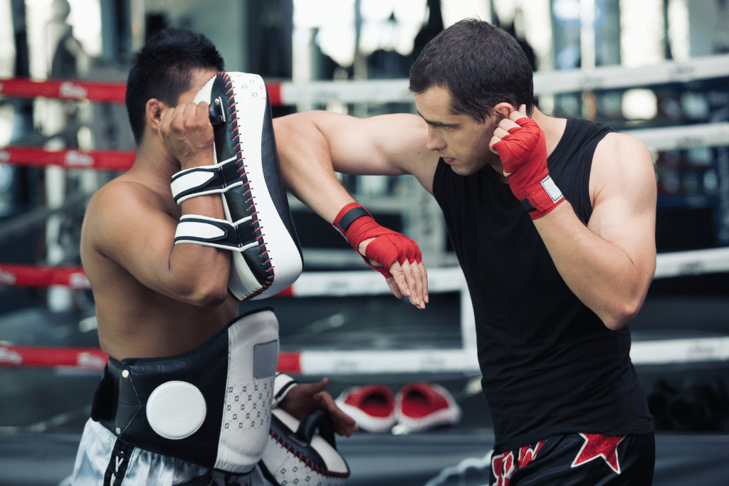 2 hombres practicando muai thai en un gimnasio